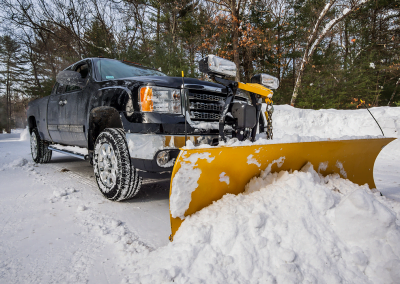 A person plowing snow in a pick up truck