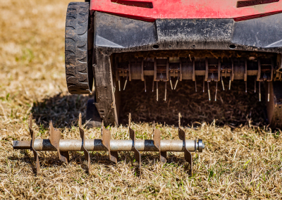 A photo of an electric aeration machine aerating a lawn